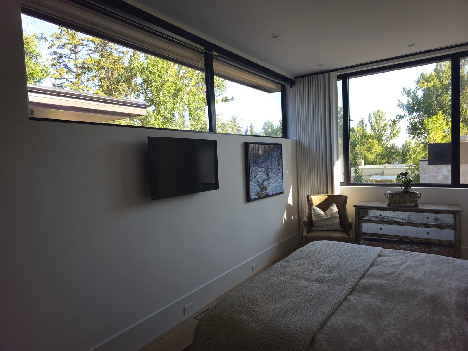 Bedroom with a television wall-mounted above a dresser