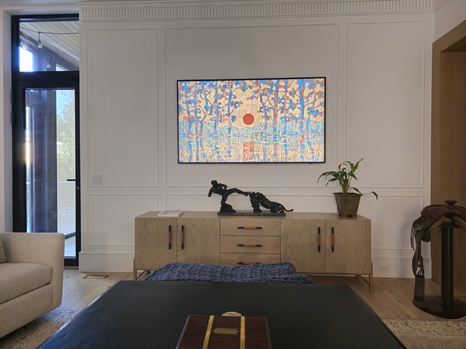 Framed-art TV mounted flush on a white panelled feature wall