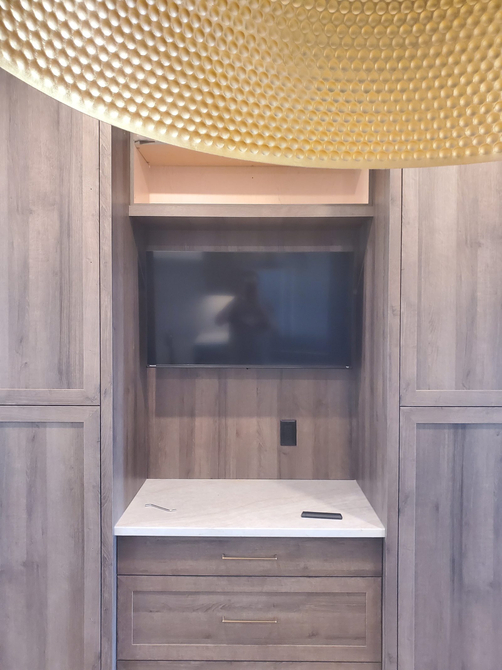 Recessed wood-paneled niche with a wall-mounted television centered inside it